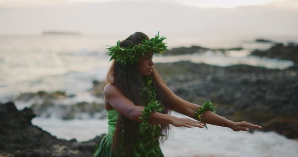 Woman performing traditional Hawaiian hula by the ocean alt
