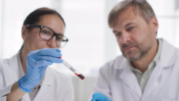 Scientists Studying Blood Sample and Talking