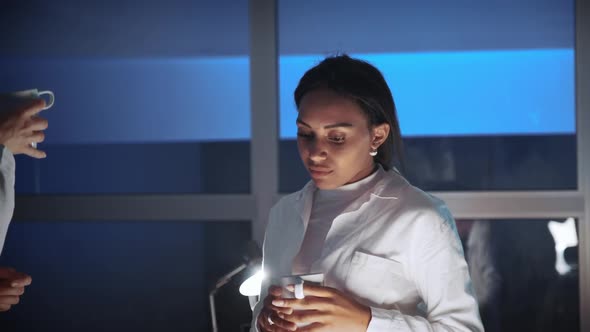 Close Up of African American Female Engineer Discussing Something with Cup of Drink in Lab
