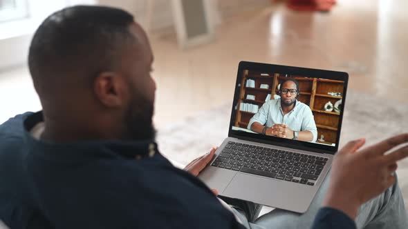 AfricanAmerican Man Taking Online Language Classes Online Teacher on Laptop Screen