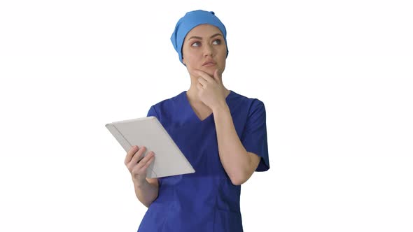 Young Woman Doctor or Nurse in Scrubs Using a Touchscreen Computer While Walking on White Background