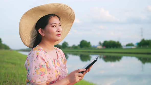 Adult woman sitting on the lawn using portable technology. Portable device tech usage concept.