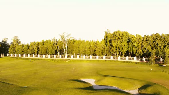 Fly Low Over Golf Grass Field with Dried Ponds