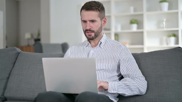 Sick Man Working on Laptop and Coughing at Home 