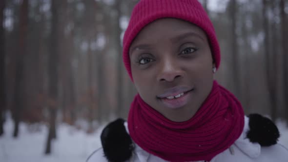 Portrait Cute Smilling African American Girl Wearing a Red Hat and a Red Scarf Standing in Winter