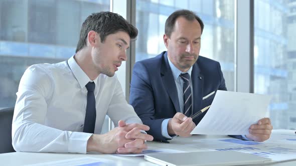 Two Businessmen Working on Documents