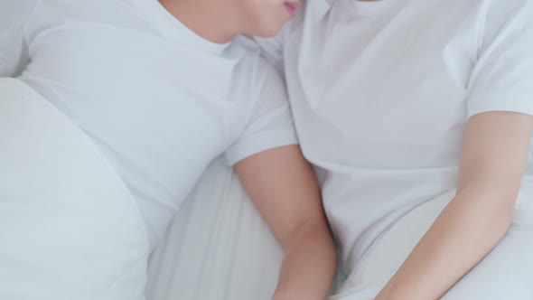 Asian young male gay family lying down on bed and look at each other.