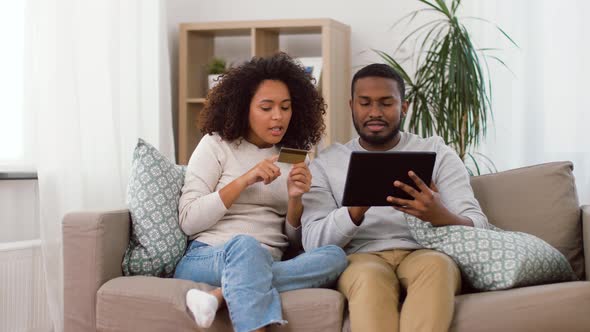 Couple with Tablet Pc and Credit Card at Home