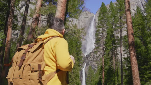 Handsome Male Traveller with Backpack at Yosemite Waterfall in National Park