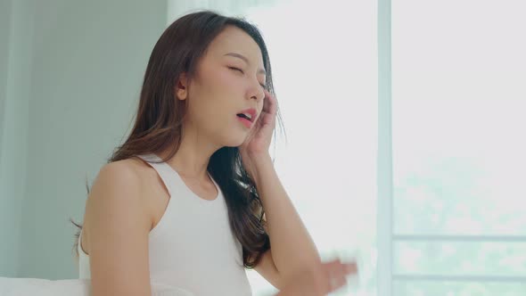 Asian young Woman has a Migraine and headache after wake up in the morning,Healthcare Concept