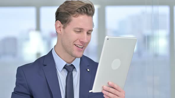 Portrait of Attractive Young Businessman Doing Video Chat on Tablet