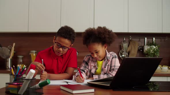 Cute Positive School Age African American Siblings Learning Online at Home