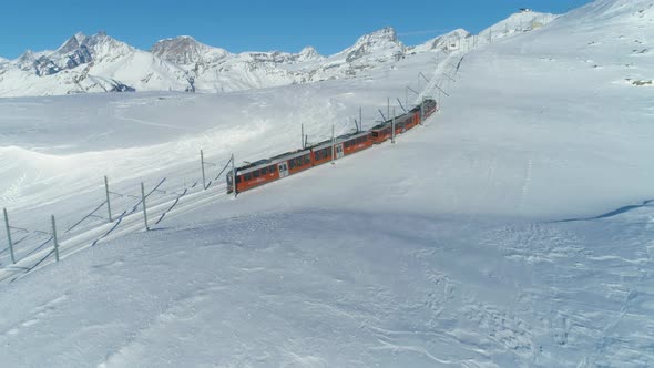 Cog Railway Train in Sunny Winter Day. Swiss Alps. Switzerland. Aerial View