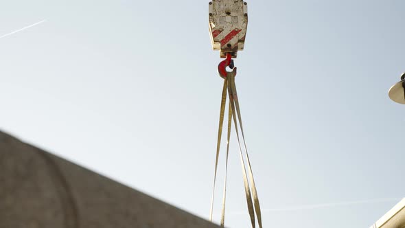 Crane picking up large truck.