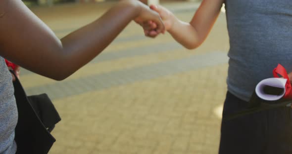 Video of hands of diverse boys congratulating each other after graduation in front of school