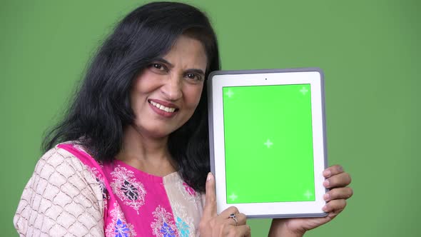 Mature Happy Beautiful Indian Woman Smiling While Showing Digital Tablet