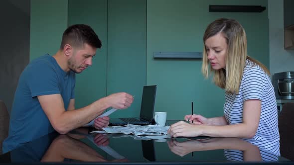 Man and Woman Looking at Payment Bills in the Kitchen