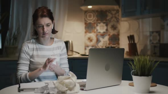 Woman In The Kitchen With Laptop, She Rips The Leaves Off Her Notebook And Throws Them Away