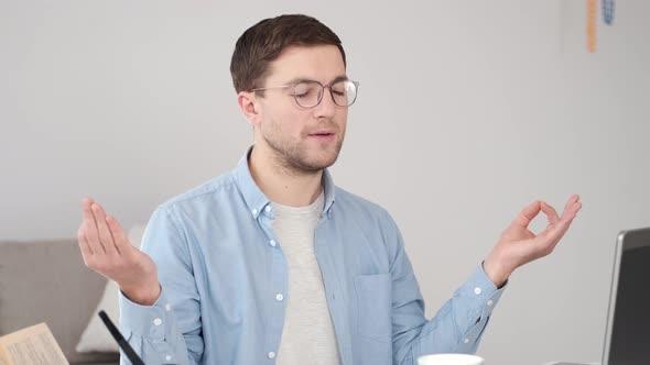 Calm Young Man Relaxing with Laptop in Yoga Position