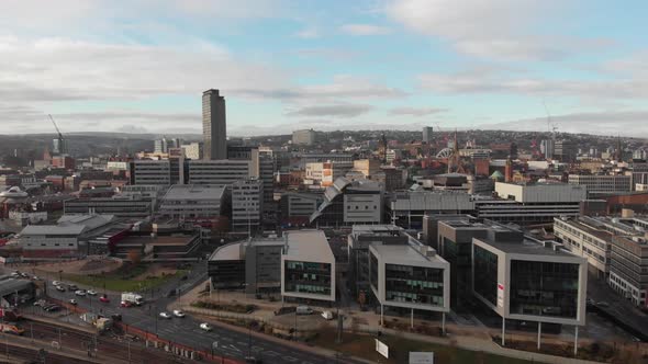 Drone shot above the city of Sheffield, panning over the Train Station, Sheffield Hallam, Park Hill