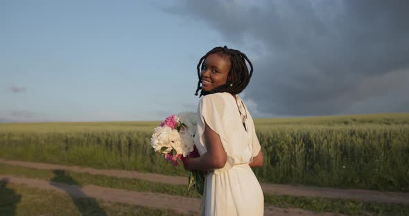 Beautiful Black Woman with Flowers Walk in the Field