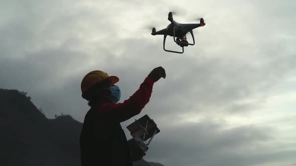 Male engineer doing inspection using drone while wearing face mask