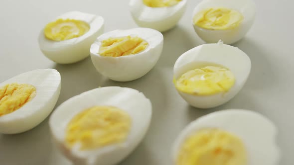 Video of close up of halves of hard boiled eggs on grey background
