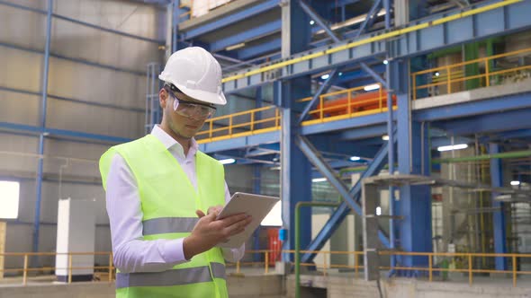 Engineer using Tablet pc in factory.