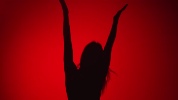Silhouette Happy Woman Jumping Enjoying Freedom Isolated on Red