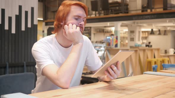 Casual Redhead Beard Man Using Tablet PC in Cafe