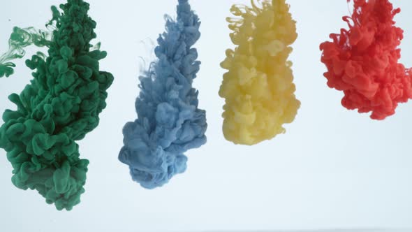 Slow motion shot of green, blue, yellow and red ink flowing into water, shot with Phantom Flex 4K ca alt