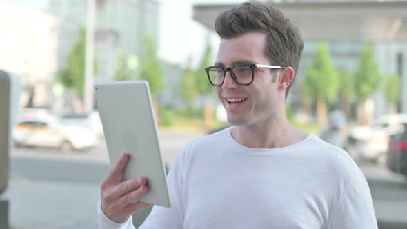 Video Call on Tablet By Young Man Outdoor