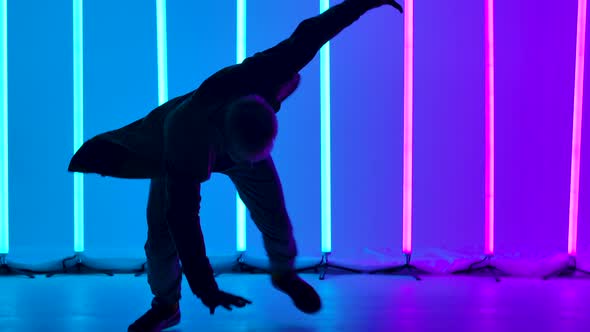 Breakdancing Acrobatic Elements Performed By a Professional Dancer Against the Backdrop of Bright