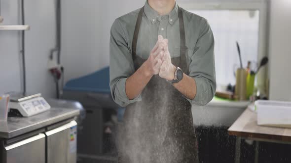 Handsome Male Baker Claps and Scatters White Flour in the Air