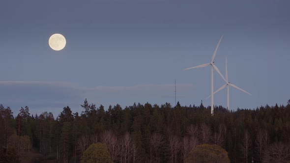 FULL MOON, TWILIGHT - Wind turbines spin fast next to a rising full moon