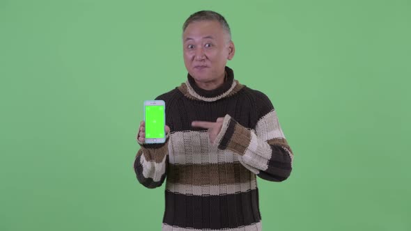 Happy Mature Japanese Man Showing Phone and Giving Thumbs Up