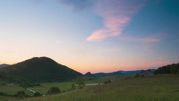 Time lapse: Sunset sky over Montelago highlands, Marche, Italy. Clear sky at dusk above unique hills