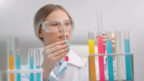 Enthusiastic Female Researcher in Uniform Safety Glasses Mixing Chemical Reagent Tube Making Testing