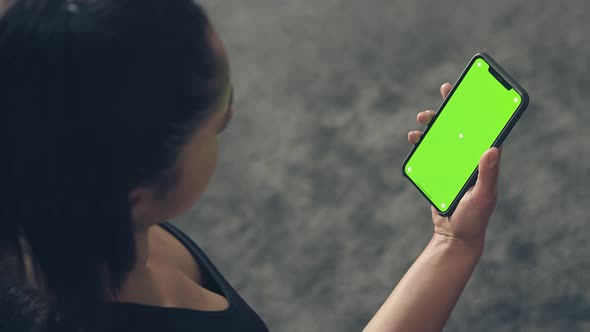 Back View of Fitness Woman Using Green Screen Smart Phone at Home