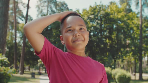 Portrait of Cute Boy Looking Into Camera Smiling Charmingly Outdoors