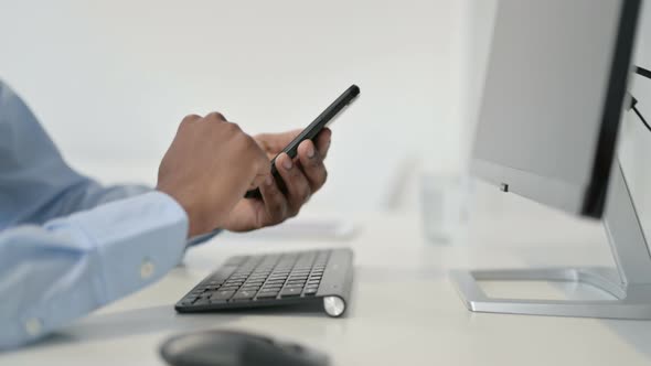 Hands of African Man Using Smartphone Close Up