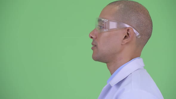 Closeup Profile View of Happy Bald Multi Ethnic Man Doctor with Protective Eyeglasses Talking