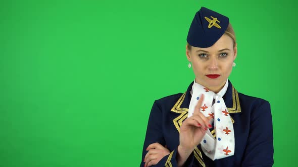 A Young Beautiful Stewardess Frowns and Shakes Her Head at the Camera - Green Screen Studio