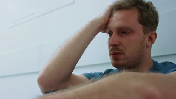 Upset Surgeon Looking Ahead Sitting on Floor Closeup