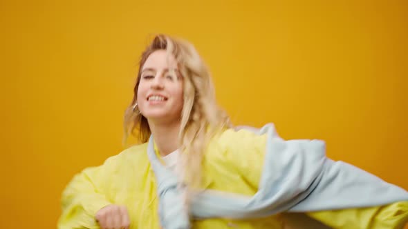 Woman Professional Dancer Dancing in Studio Against Yellow Background