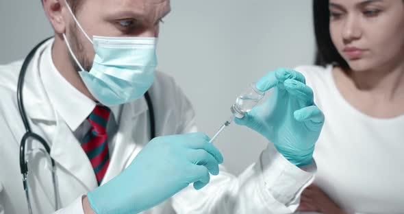 Doctor Making Vaccination Injection To Female Patient