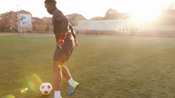 An African American Woman Training on the Football Field and Fulfills Feints with the Ball in Motion