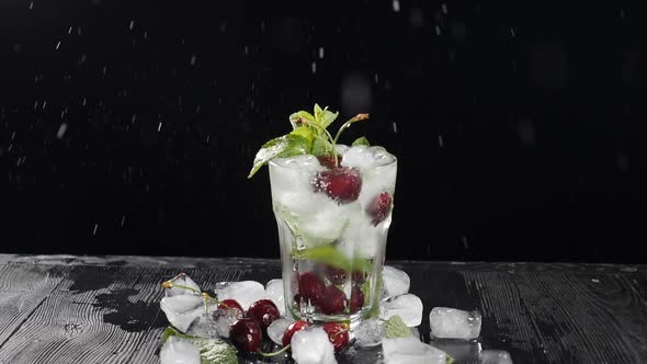Red Cherry Berry Falling Into Sweet Cocktail with Splashes in Slow Motion. Bartender Making Cocktail