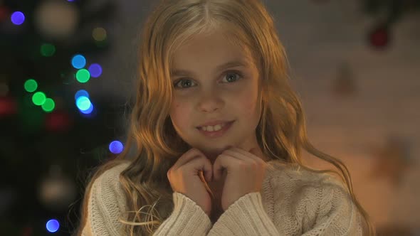 Happy Cute Girl Smiling at Camera, Waiting for Miracle at Christmas, Closeup