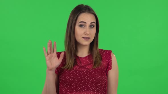 Portrait of Tender Girl in Red Dress Is Waving Hand and Showing Gesture Come Here, Flirting. Green